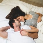 couple-lying-on-the-bed-holding-hands-and-looking-into-each-other-s-eyes_23-2147596020