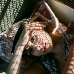 Delicate light and shadow fall on her delicate hand and face