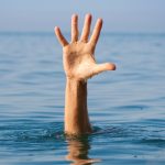 single hand of drowning man in sea asking for help