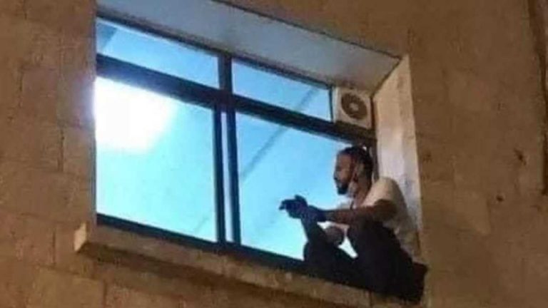 Muž vylezie na okno nemocnice a pozerá sa na svoju mamu, ktorá umiera na koronavírus